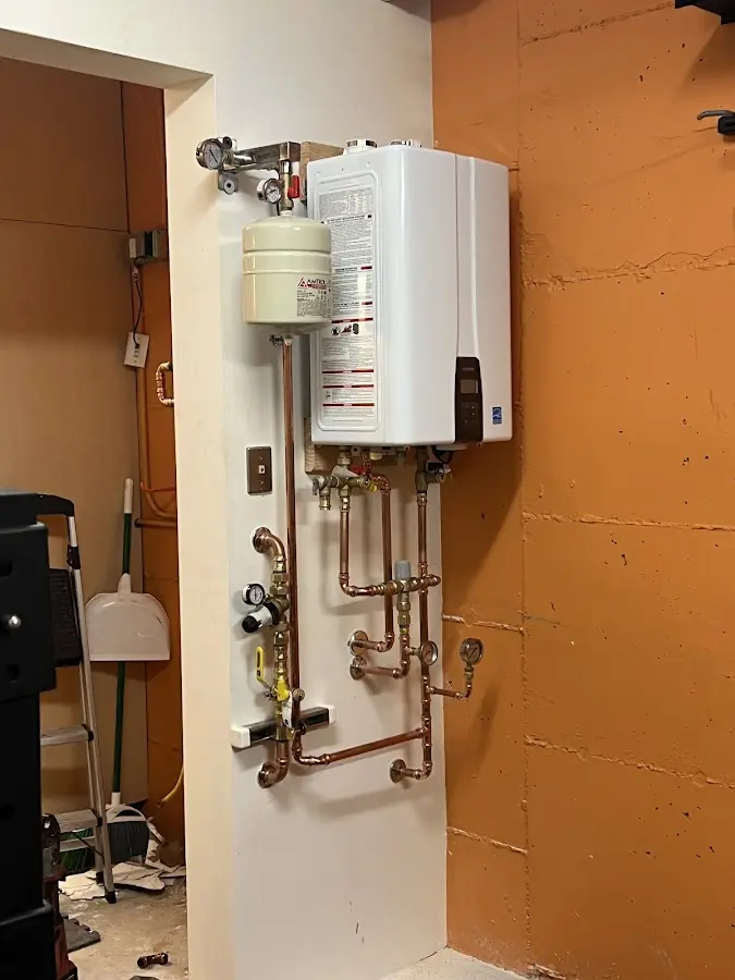 Plumbing technician inspecting water heater connections in Walworth